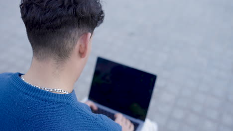 young man working on laptop outdoors, multiple views