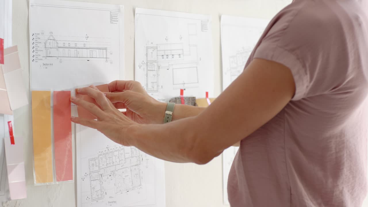 Woman placing pink swatch spotting match pinup layering strips finishing scheme, copy space