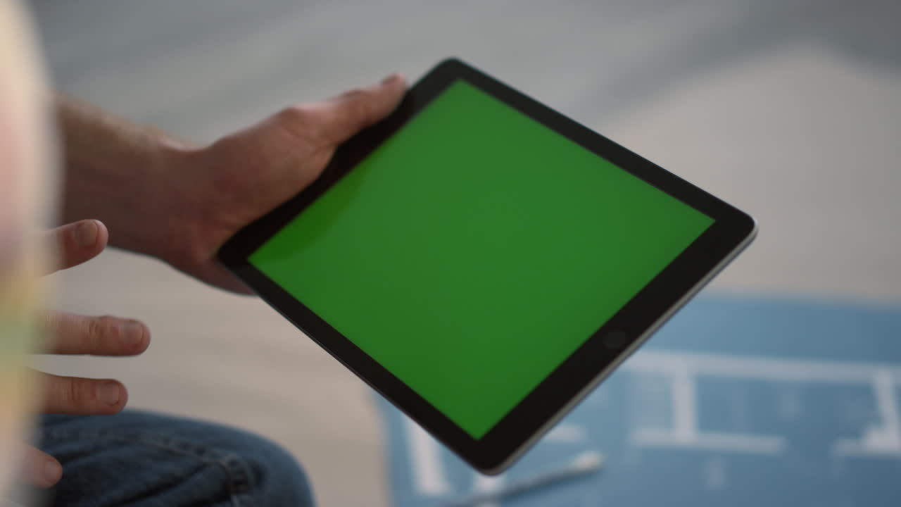 un hombre desconocido con una tableta en el interior, un tipo que usa una aplicación de construcción para la renovación del hogar.