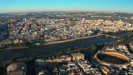 Drone-Panorámico-Aéreo-Del-Río-Navegable-Guadalquivir-En-Córdoba-España-Ciudad-Calles-Barrio-Y-Horizonte-De-Luz-Diurna