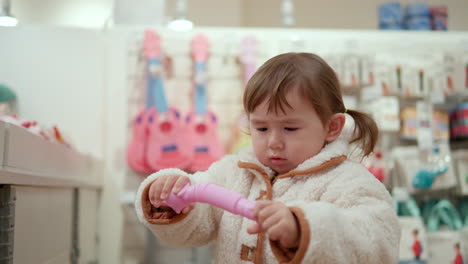 Niña-Curiosa-Probando-Un-Juguete-En-El-Centro-Comercial