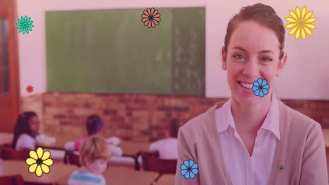 Composite-video-of-colorful-flower-icons-floating-against-caucasian-female-teacher-smiling-in-class