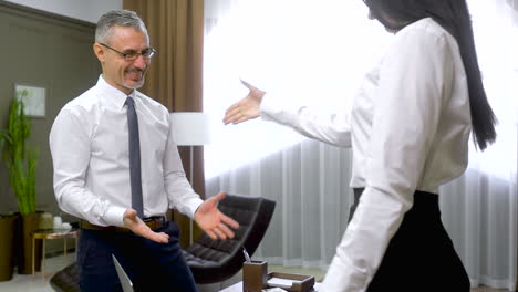 happy male employee giving document to his boss and then, they shaking hands at the office