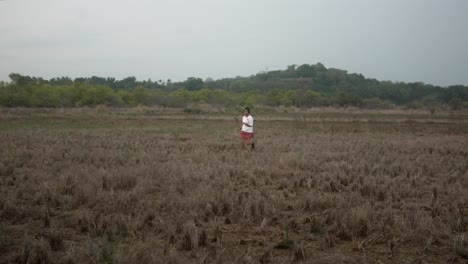 Un-Niño-Corre-Por-Un-Campo-Seco-En-Un-Día-Nublado