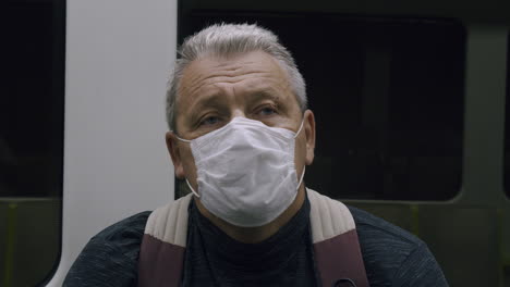 senior in a protective mask in a subway car