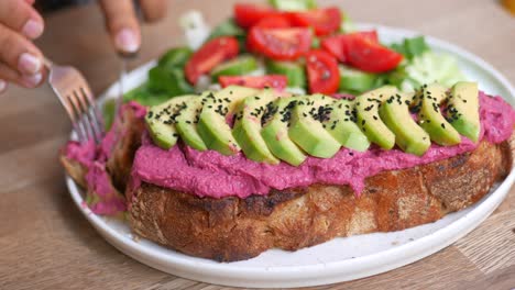 delicious avocado toast with beetroot hummus and a side salad