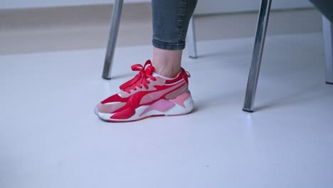 woman tying shoelace indoor. close up view of woman hands tying shoelaces on sneakers