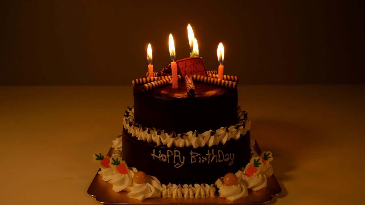 4k de feliz pastel de cumpleaños con velas en espiral encendidas