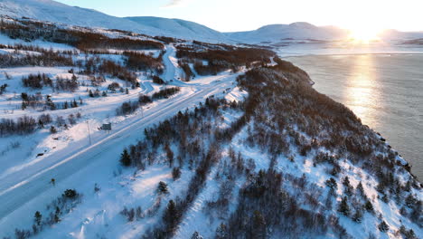 Sonnenuntergang-Direkt-über-Den-Schneebedeckten-Gipfeln-Auf-Dem-Offenen-Meer,-Während-Touristen-An-Einem-Aussichtspunkt-Anhalten