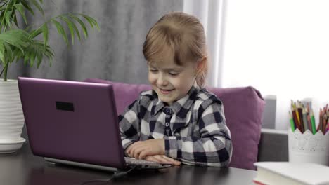 Girl-doing-lessons-at-home-using-digital-laptop-computer.-Distance-education