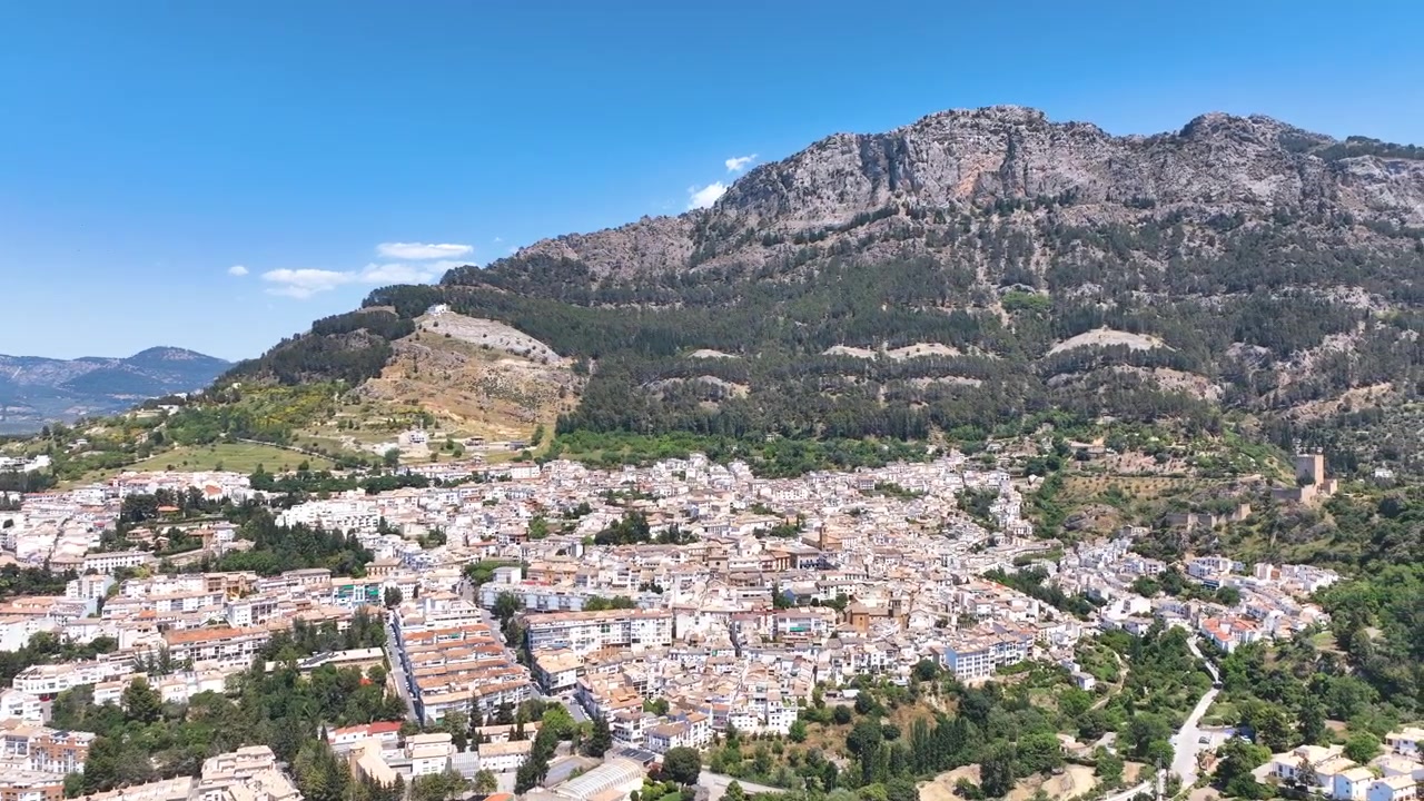 O voo vira à direita sobre os telhados da encosta e o fundo de montanhas íngremes da famosa cidade de Cazorla, na Andaluzia, e entrada para o Parque Nacional. Espanha.