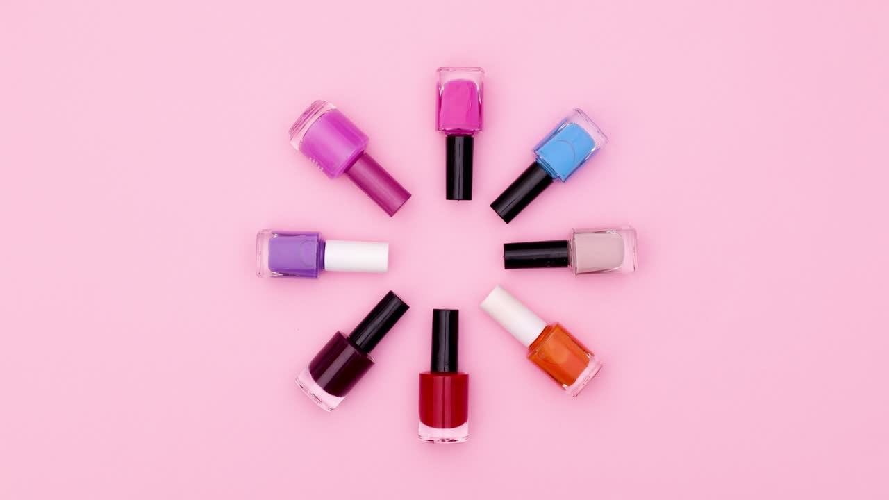 Black nail polish bottles move in circle and change colors. Stop motion