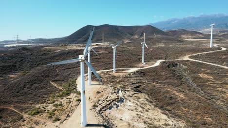 Dron-De-Muñeca-En-Movimiento-Lento-Tiro-De-Molinos-De-Viento-Contra-Los-Vastos-Desiertos-De-España,-Durante-El-Día