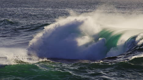 slow motion wave crashing as ocean spray mist rises off top, natural backdrop background