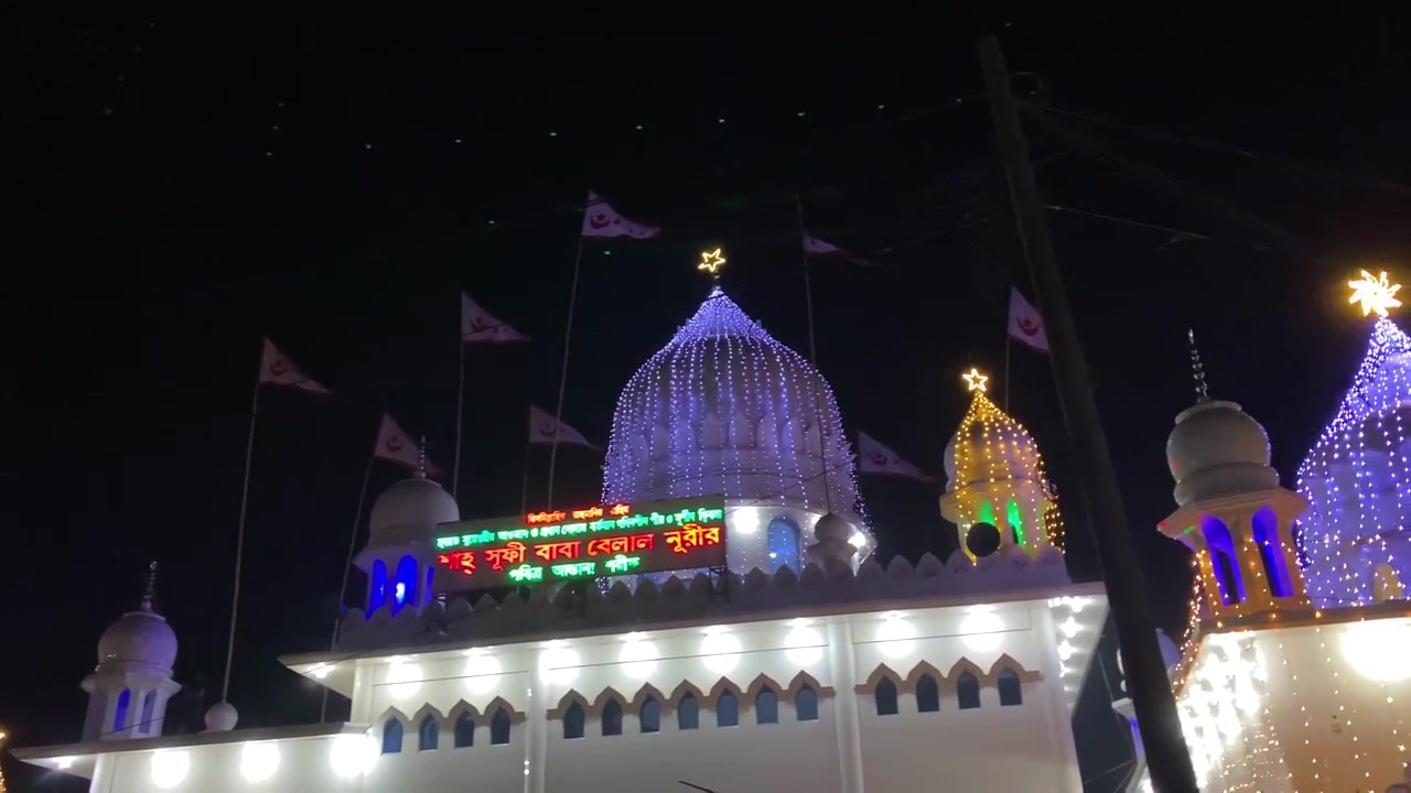 Sureshwar Mazar shrine illuminated domes night lights flags religious site Shariatpur Bangladesh Islamic architecture spiritual landmark.