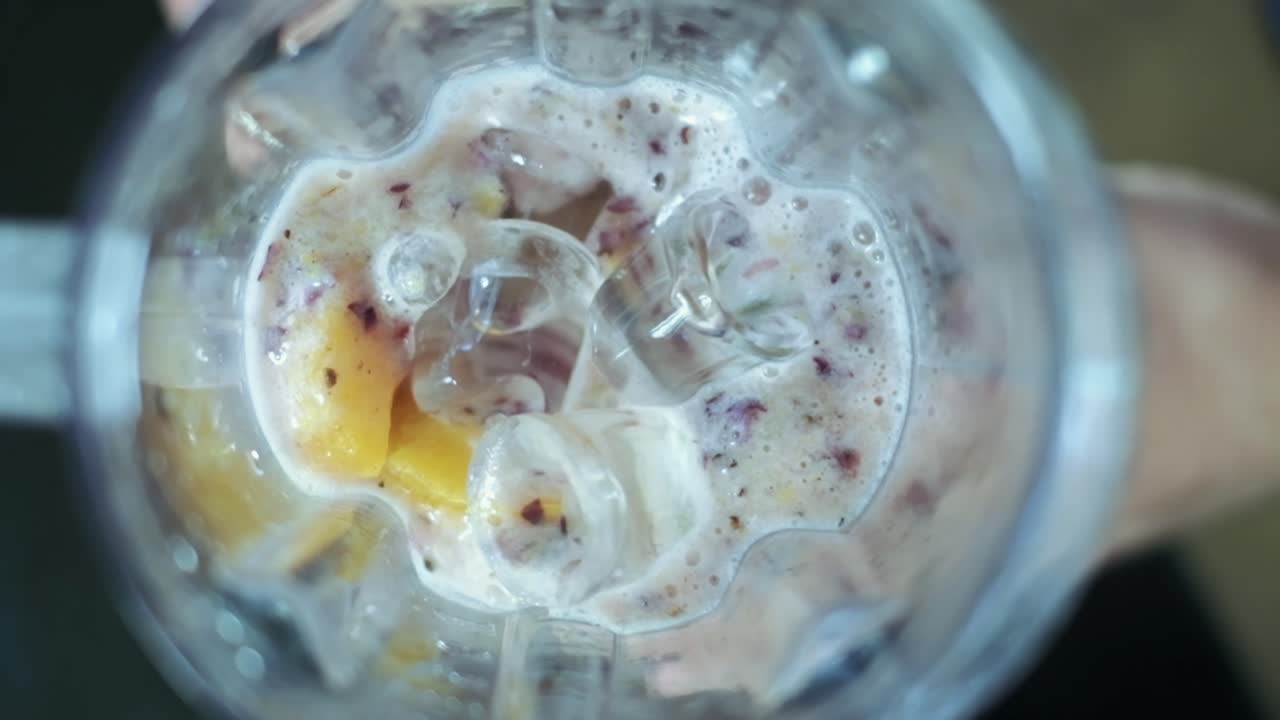 Frossen blanding filmet i sakte film ovenfra, med jordbær, appelsin og yoghurt med is.