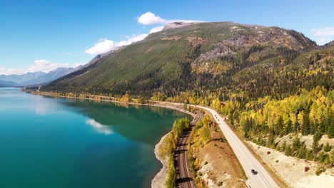 Vista-Panorámica-Derecha-Aérea-De-La-Autopista-Cabeza-Amarilla-A-Lo-Largo-Del-Lago-Moose-En-El-Parque-Provincial-De-Monte-Robson-En-Otoño-Con-árboles-Amarillos-Y-Montañas-En-El-Fondo-Y-Automóviles-Conduciendo-Por-La-Autopista