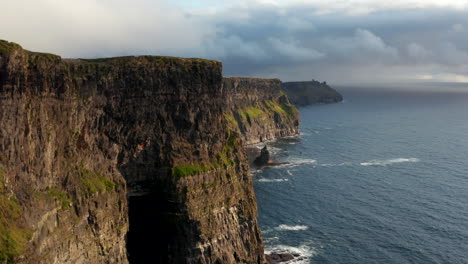 Vorwärts-Fliegen-Sie-Entlang-Atemberaubender-Malerischer-Klippen.-Hohe-Vertikale-Felswände,-Die-In-Gekräuseltes-Wasser-Fallen.-Bewölkter-Himmel.-Klippen-Von-Moher,-Irland