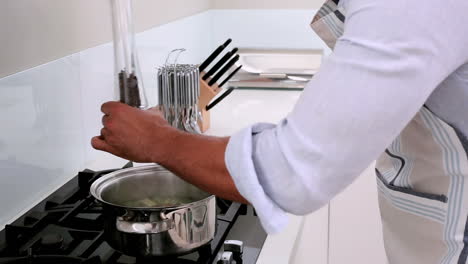 handsome man adding and flavoring vegetables in the pot