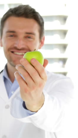 doctor sosteniendo una manzana verde
