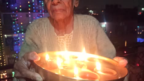 an old woman celebrating diwali happily ,