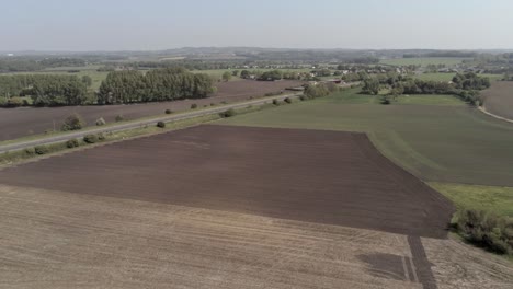 drone aerial view rising left above british a580 east lancs highway in rural agricultural countryside