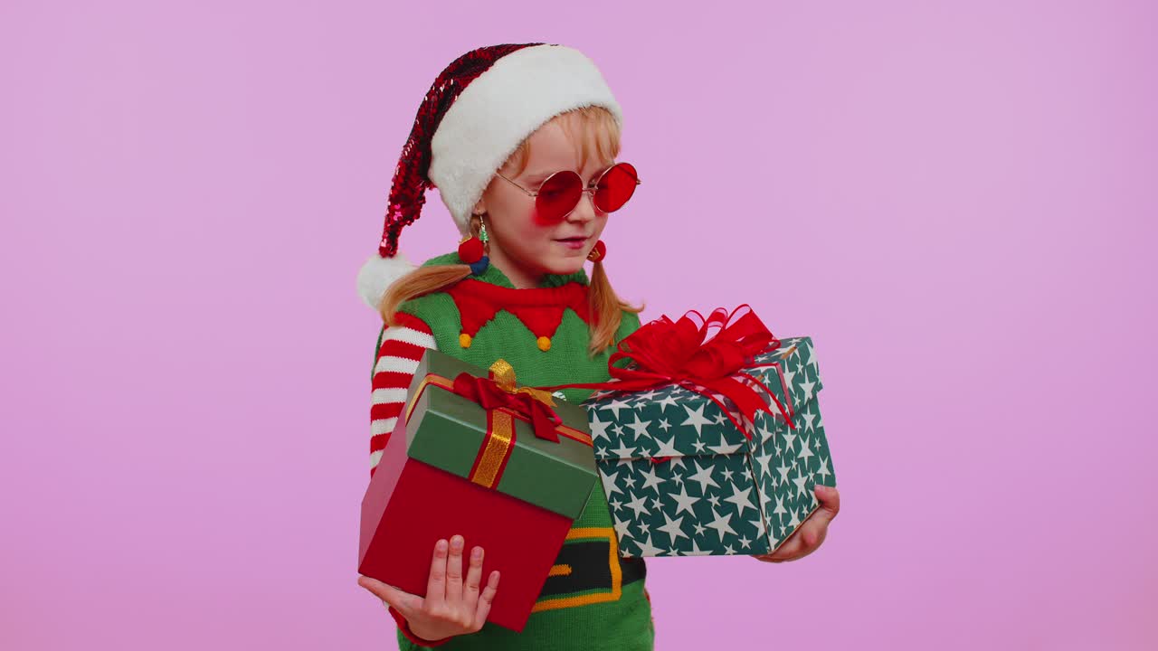 Dívka batole, Vánoce, Santa Claus, elf drží v rukou dvě dárkové krabice, nákupy, prázdniny, výprodej