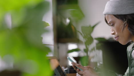 close up hands young african american woman using smartphone in cafe browsing online reading social media messages texting enjoying drinking coffee relaxing in trendy restuarant