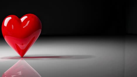 A glossy red heart on a reflective surface, captured from a low-angle