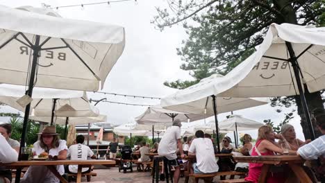 people enjoying food and drinks at outdoor tables