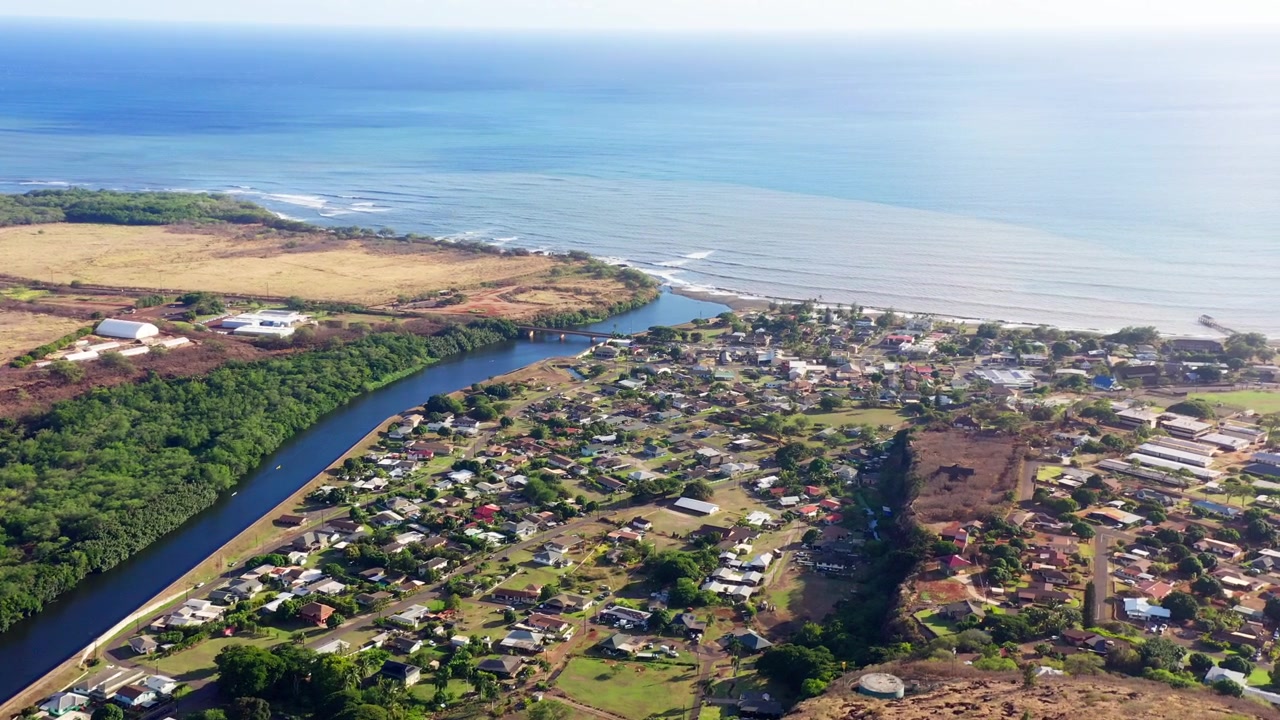 Rekaman drone udara Sungai Waimea yang mengalir ke Teluk Waimea di pulau hijau Kauai, Hawaii. Rekaman siang hari melihat ke arah kota pantai menuju Samudra Pasifik. Direkam dalam 4K