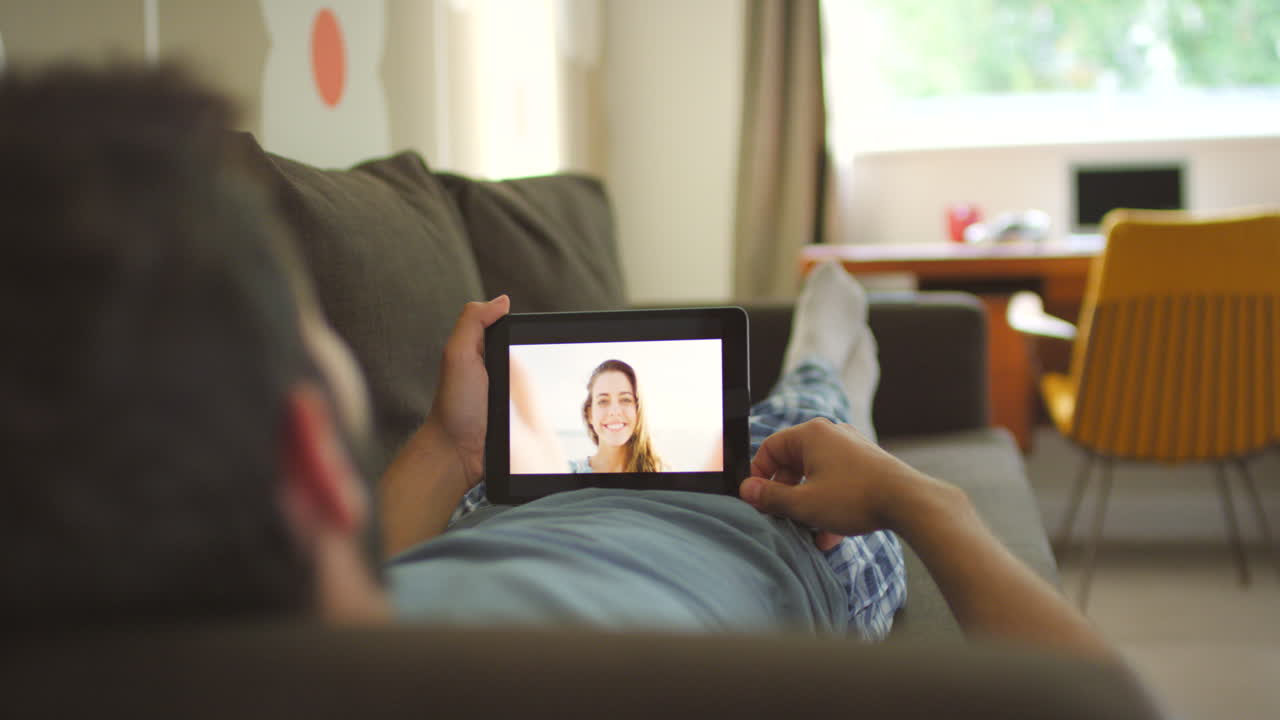 pareja disfrutando de una llamada de video en casa