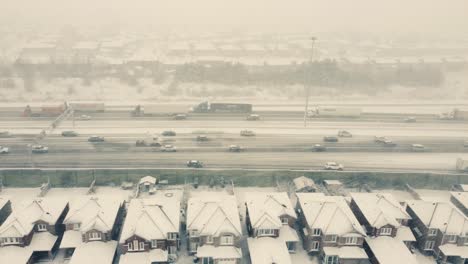 Luftaufnahme-über-Stark-Befahrener-Autobahn,-Schneesturm,-Häuser-Der-Mittelklasse