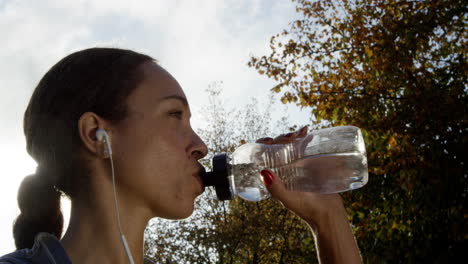 runner woman drinking water bottle sun flare solar energy