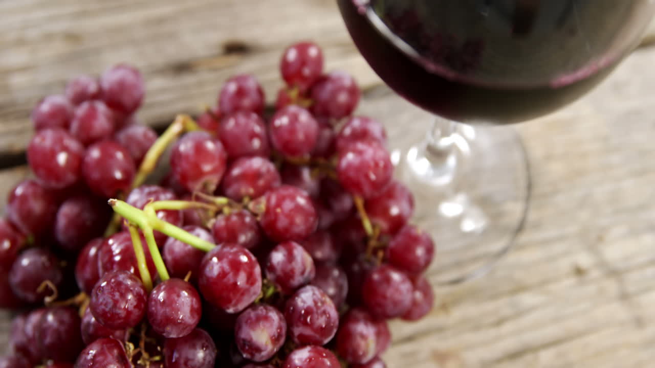 uvas y vino tinto en una tabla de madera