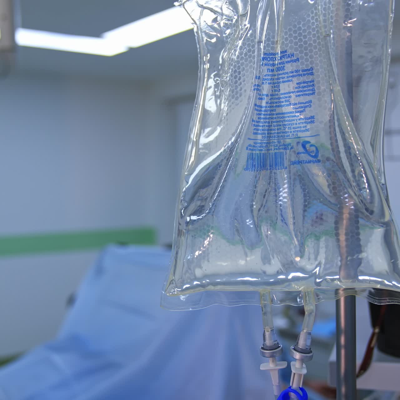 Fragment of a dropper in the operating room. Surgeon's team performing a surgery. Sterile packet with medicine during the surgical process. Close-up