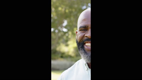 vertical video: smiling outdoors, senior man enjoying nature and fresh air in park
