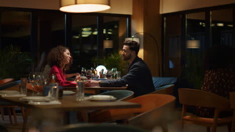 una pareja de raza mixta saliendo en una mesa de restaurante de lujo. los amantes disfrutan del tiempo juntos.