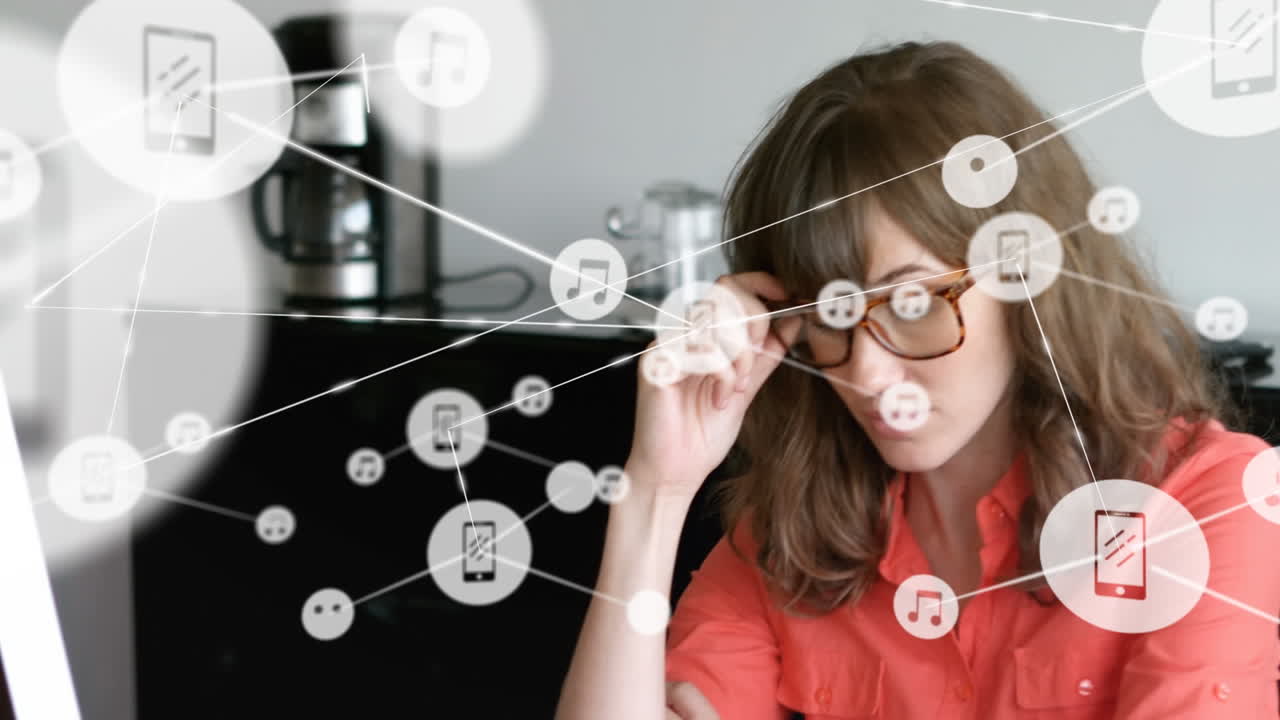 animación de iconos de teléfonos y música conectados sobre una mujer de negocios caucásica pensando en el escritorio