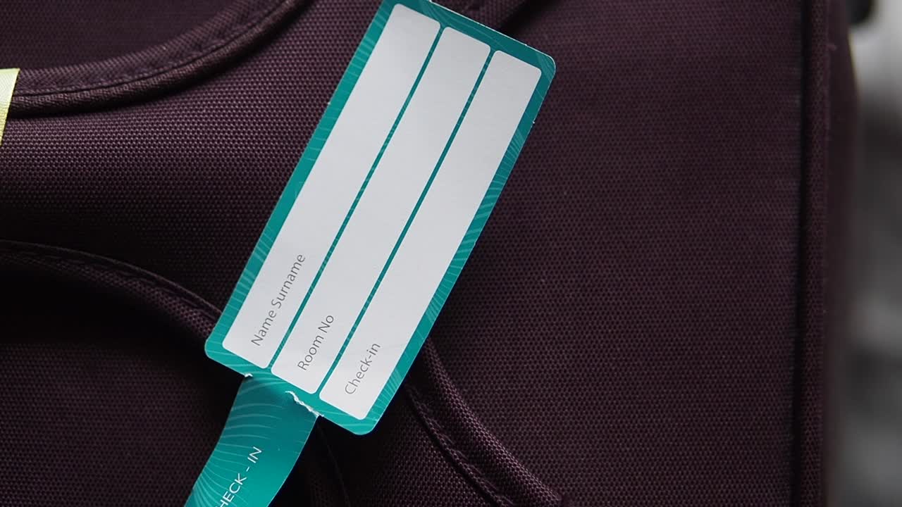 Detailní záběr prázdné jmenovky na cestovním kufru
