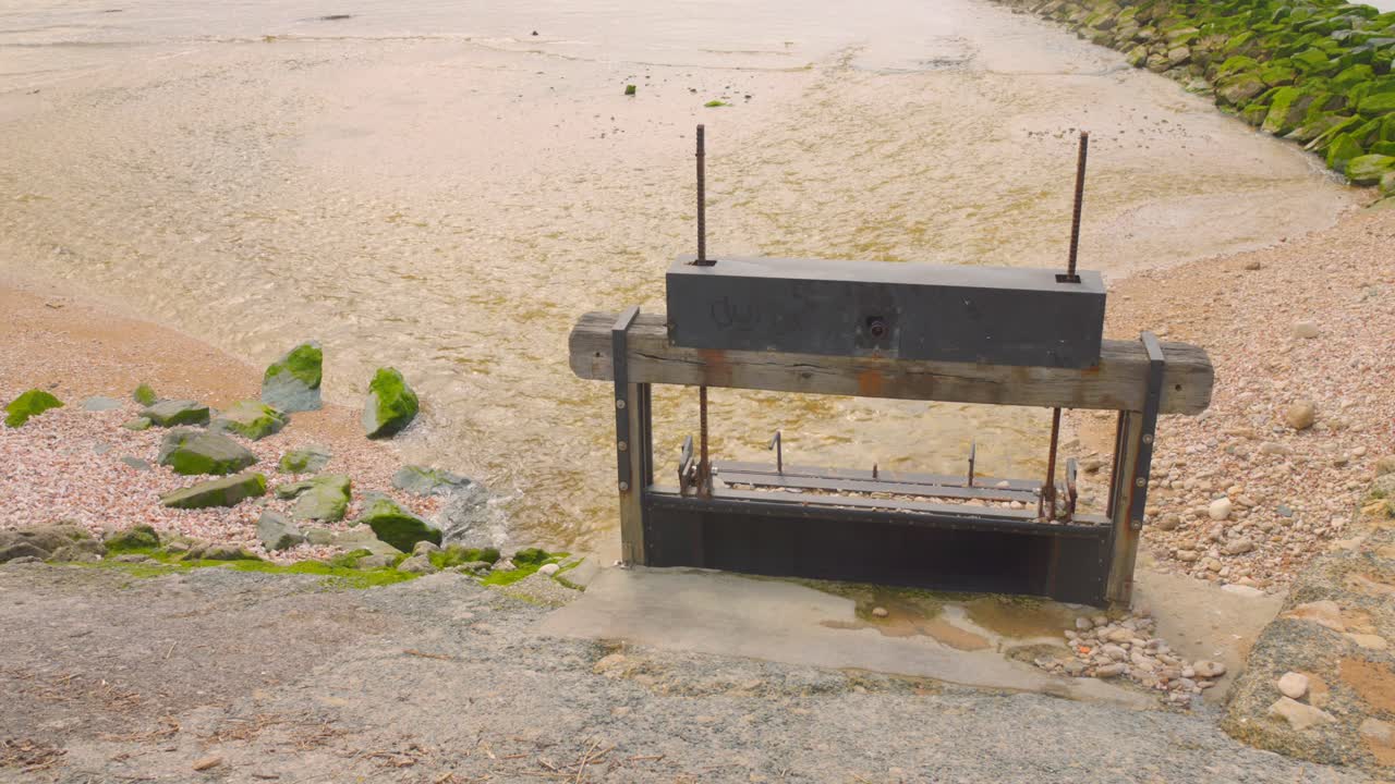 Coastal Sluice Gate on a Rocky Beach