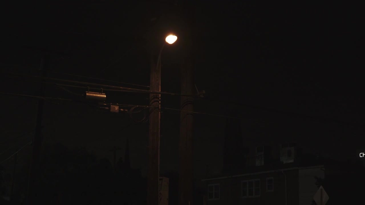 Close-up video of a streetlight or lamplight illuminating the street of Los Angeles at night