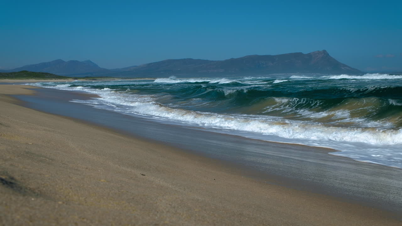 olas rompiendo en la prístina playa de kleinmond, costa de ballenas del cabo, sudáfrica