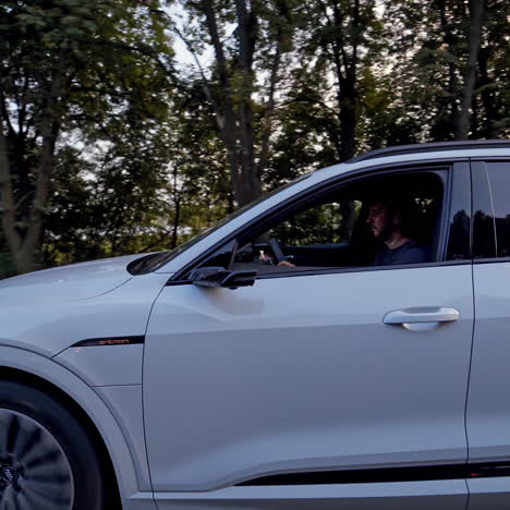 beautiful electric light blue car on the road. outdoor view on audi car travelling on highway on the background of green trees.