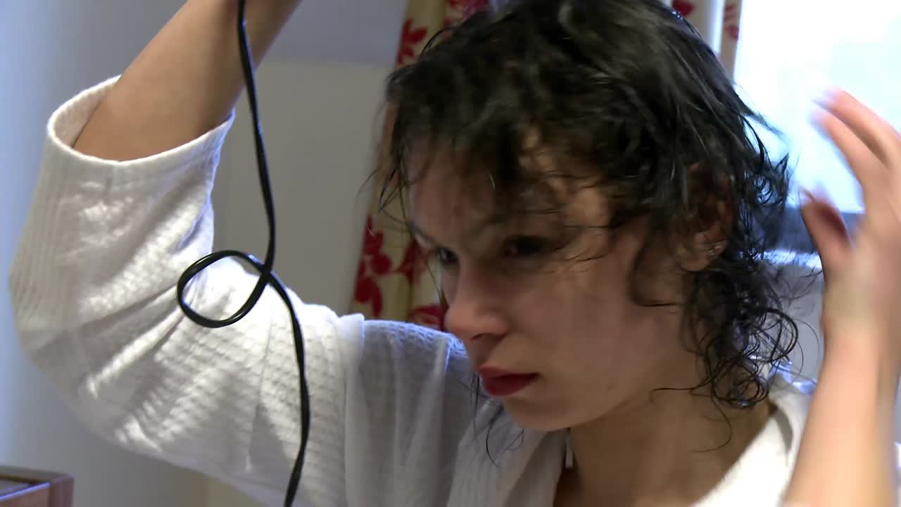 mujer encantadora secándose el cabello