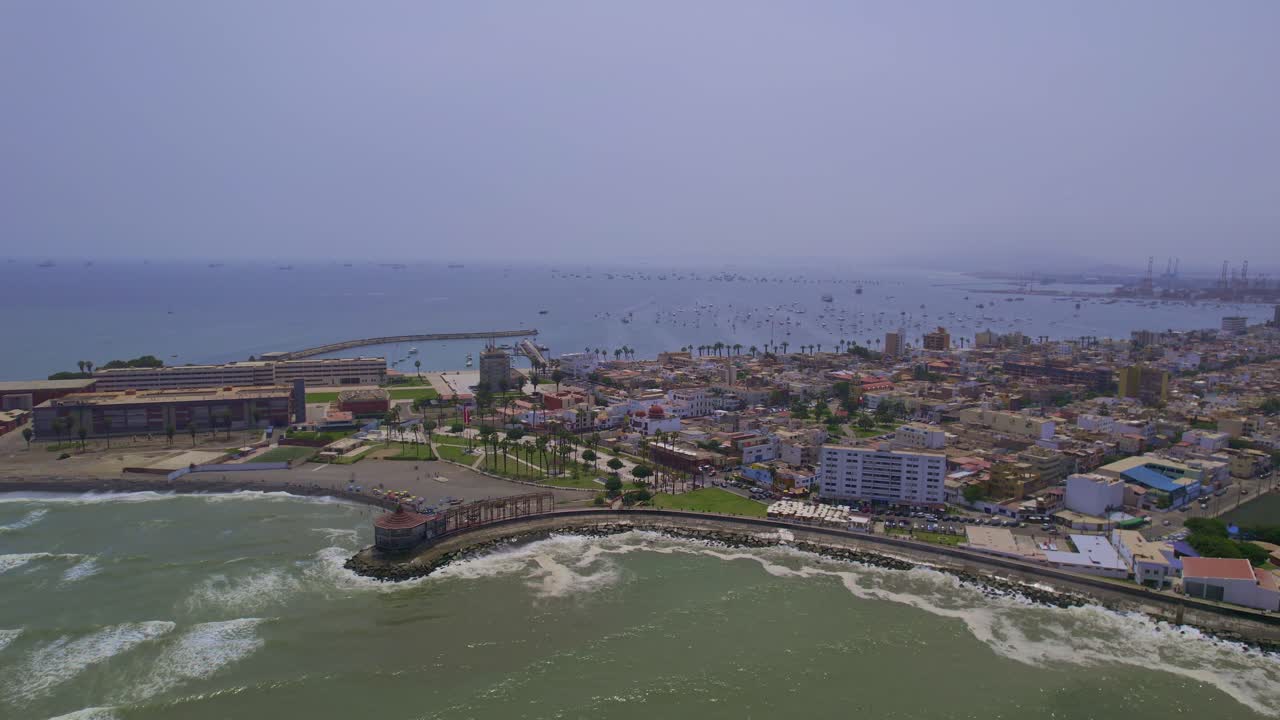 Vista Aerea di una Città Costiera con Porto e Onde dell'Oceano