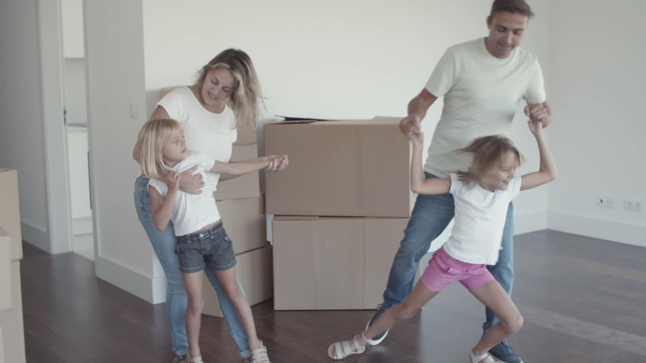 padres e hijos bailando en su nuevo apartamento