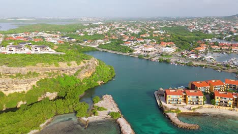 vista royal and caracasbaai neighborhood with beach resort and marina below cliffs in curacao