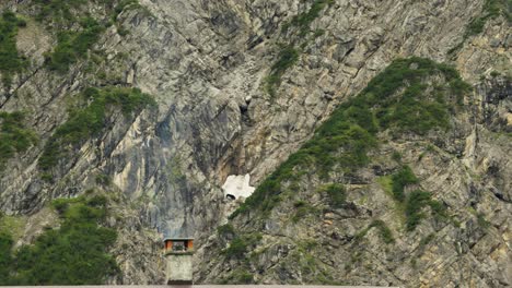 chimney smoke against steep rocky mountain ridge