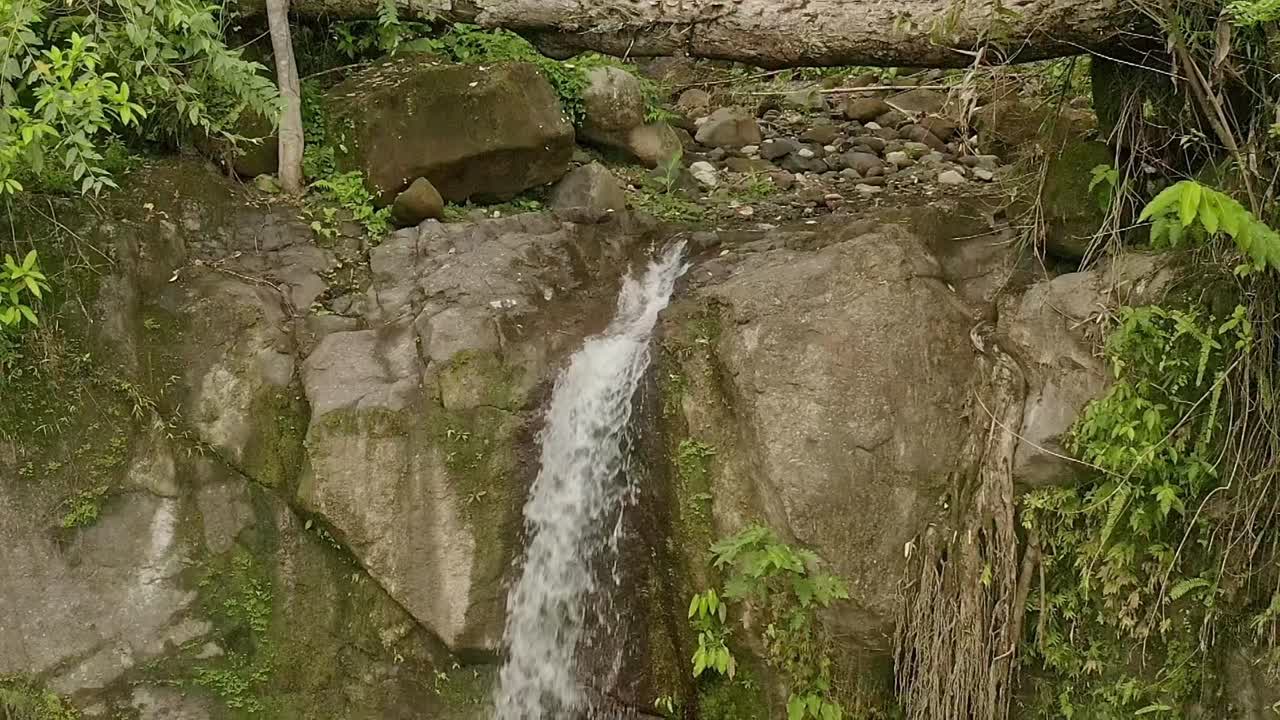 tomada inclinada hacia abajo de la remota cascada de lumondo, en lo profundo de la jungla de alegría, surigao del norte, filipinas durante el día